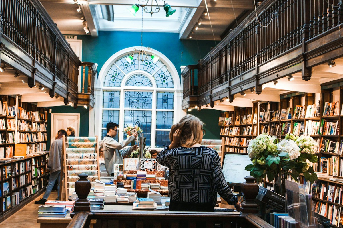 People browsing books in a sunlit bookshop